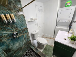 Un baño con inodoro, lavamanos y zona de ducha.
