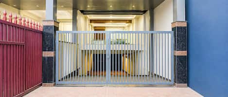 A gated entrance with a metal gate and a red fence.