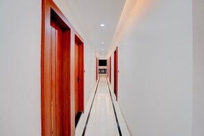 Ein Hotelkorridor mit Holztüren und Fliesenboden.