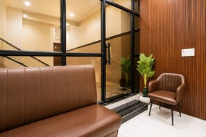Un interior moderno con un banco de cuero, una pared de madera y una planta en maceta.