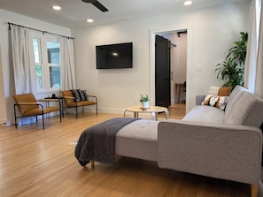 A modern living room with a sofa, chairs, a coffee table, and a TV. - Charming 2 bedroom bungalow in downtown Paso Robles (Paso Robles)
