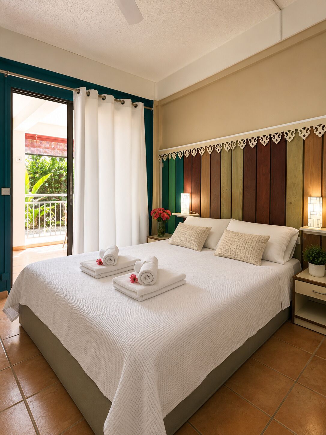 Une chambre d’hôtel avec un lit, une table de chevet, une plante en pot et une vue sur l’extérieur.