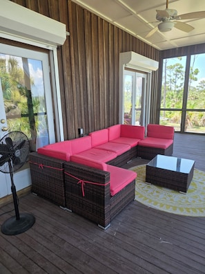A covered outdoor seating area with wicker furniture and a ceiling fan. - Bayfront Sunset Escape - 450’ Private Dock + 4 bedrooms (Port St. Joe)