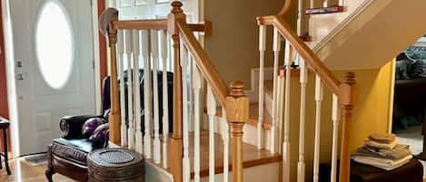 A staircase with wooden railings and a carpeted floor.