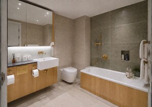 Ein modernes Badezimmer mit einem Doppelwaschtisch, einer Toilette und einer freistehenden Badewanne.