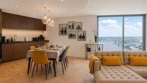 Un espacio habitable moderno con comedor, cocina y sofá con vistas.