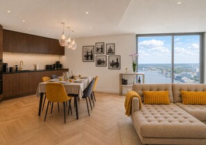 Ein modernes Wohnzimmer mit Essbereich, Küche und einer Couch mit Blick.