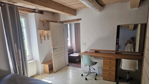 A bedroom with a bed, a desk, a chair, and a mirror. - A Provençal stone farmhouse dating from 1870, with a terrace and a pool. (Mougins)