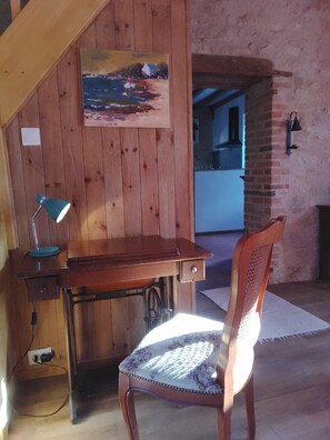 A wooden desk with a lamp, a chair, and a painting on the wall. - Charming Riverside Gite in the Brenne National Park close to amenities. (Belabre)