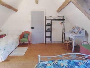 Ein Schlafzimmer mit Bett, Stuhl, Schreibtisch und Kleiderschrank.