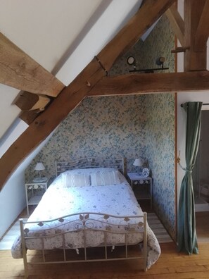 A bedroom with a bed, a nightstand, a lamp, and a wall clock. - Charming Riverside Gite in the Brenne National Park close to amenities. (Belabre)