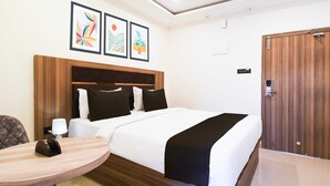 Una camera d'albergo con un letto, un comodino, una lampada e una porta.
