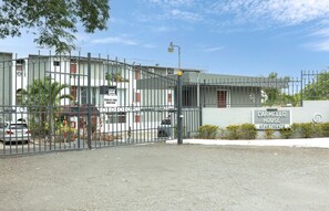 A gated entrance to a residential building with a sign indicating 'Carmello House Apartments.' - Central Retreat (Kingston)