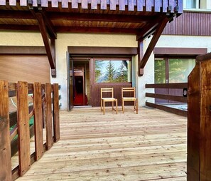 A wooden deck with two chairs and a wooden fence. - Ground floor, terrace, parking, 20m², Serre Chevalier (La Salle-les-Alpes)