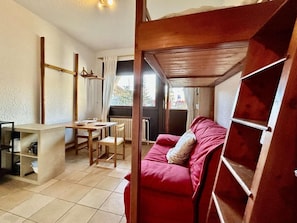A compact living space with a kitchenette, a dining area, and a red sofa. - Ground floor, terrace, parking, 20m², Serre Chevalier (La Salle-les-Alpes)