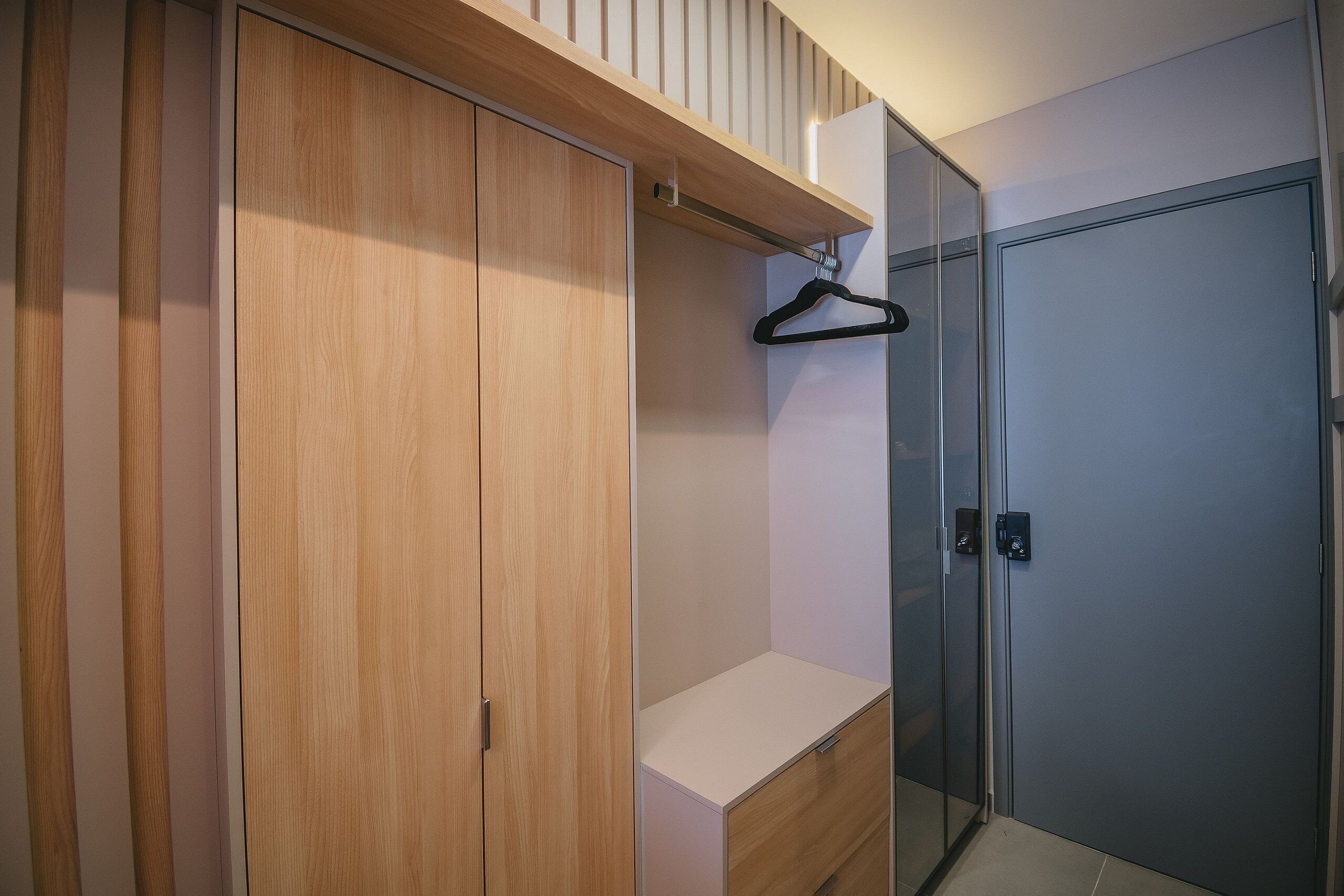 Ein modernes Badezimmer mit einem Holz-Waschtisch, einer Duschkabine aus Glas und einer hängenden Duschstange.