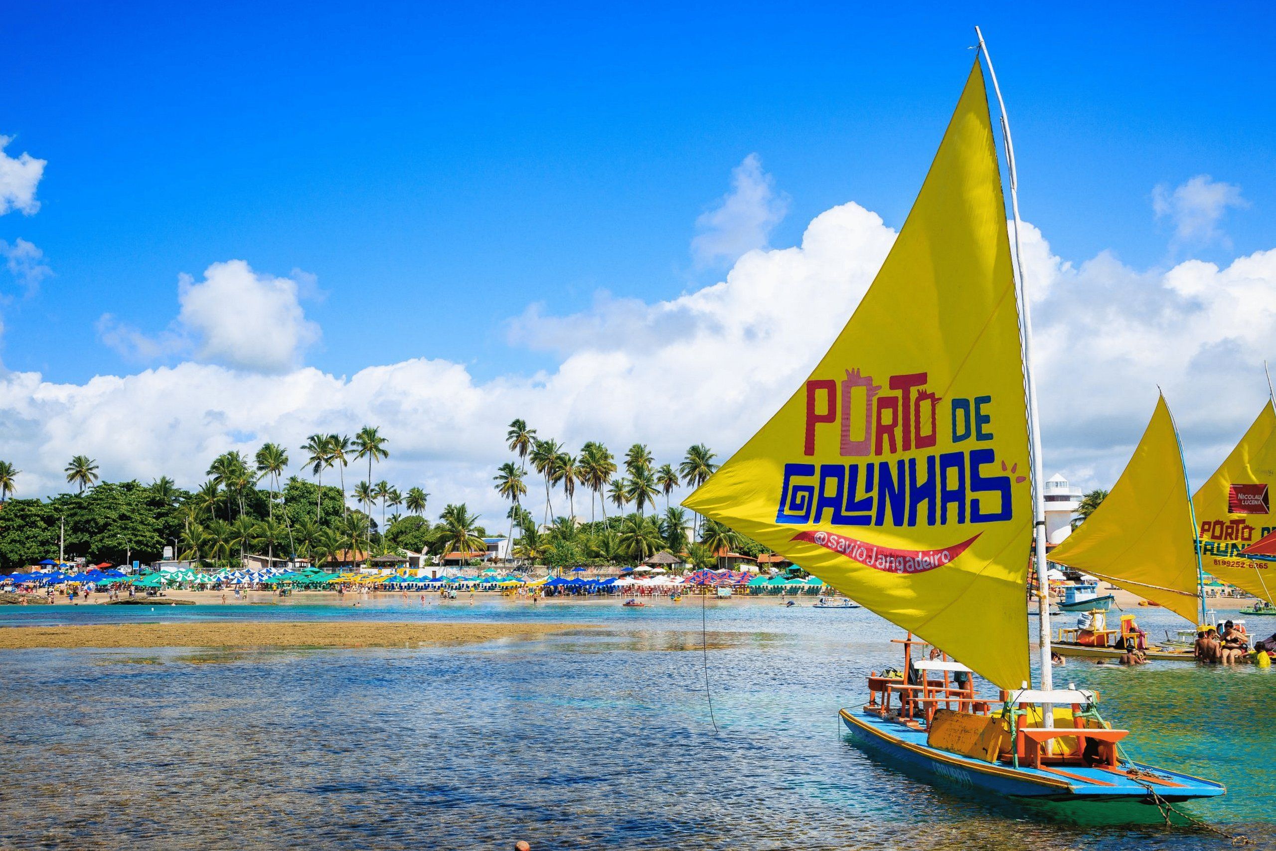 A beach scene with a boat and a yellow flag with text.