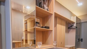 A compact kitchen with a built-in coffee maker, a blender, and a hanging coat rack. - Luxury studio apartment 3 minutes from the natural pools (Ipojuca)