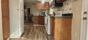 A kitchen with wooden cabinets, a microwave, and a stove.