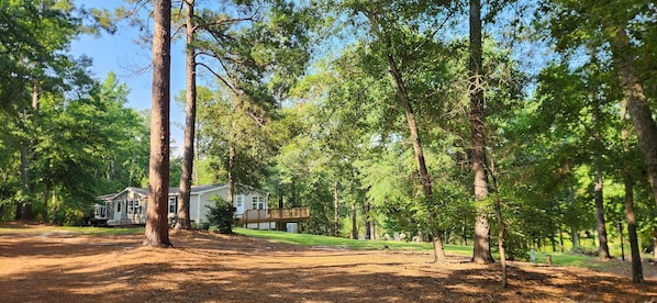 A residential area with a house, a deck, and a dirt path.