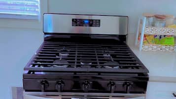 A kitchen with a stainless steel stove, a microwave above it, and a white cabinet.