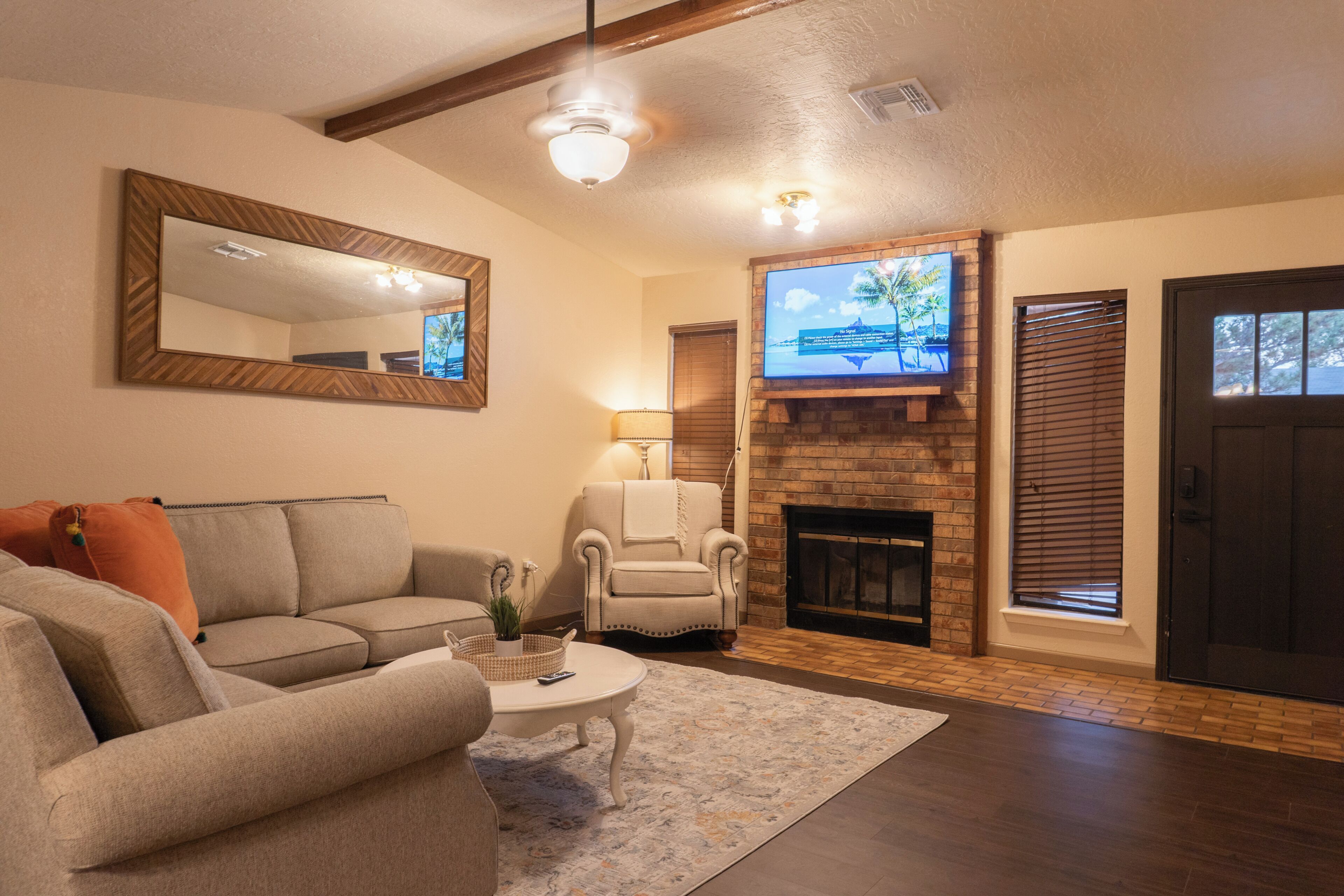 A living room with a fireplace, a television mounted on the wall, a sofa, and a coffee table.