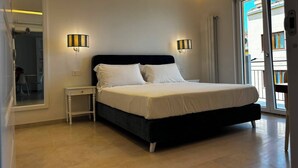 A bedroom with a bed, bedside tables, and a view of the outside. - De Vivo Realty - Panorama Suite Sorrento (Sorrento)
