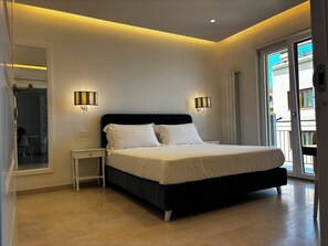 A bedroom with a bed, bedside tables, and a view of the outside. - De Vivo Realty - Panorama Suite Sorrento (Sorrento)
