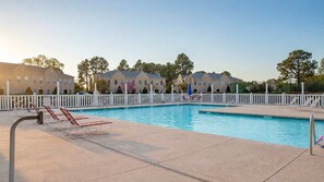 A swimming pool with lounge chairs and a white fence surrounding it. - Myrtle Beach Golf Resort Condo - Pools & Hot Tub (Myrtle Beach)