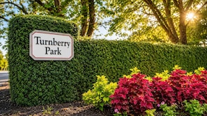 A sign for Turnberry Park with a neatly trimmed hedge and colorful plants in the foreground. - Myrtle Beach Golf Resort Condo - Pools & Hot Tub (Myrtle Beach)