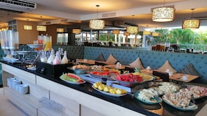 A buffet area with a variety of food items and a seating area with a blue upholstered sofa. - Beautifull Condo Apartament With sea View Morros Sonesta (Cartagena)