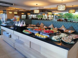 A buffet area with a variety of food items and a seating area with a blue upholstered sofa. - Beautifull Condo Apartament With sea View Morros Sonesta (Cartagena)