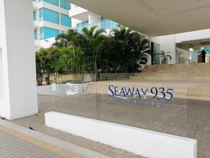 A modern building with a glass facade, outdoor seating area, and a sign for 'SEAWAY 935 CARTAGENA.' - Beautifull Condo Apartament With sea View Morros Sonesta (Cartagena)