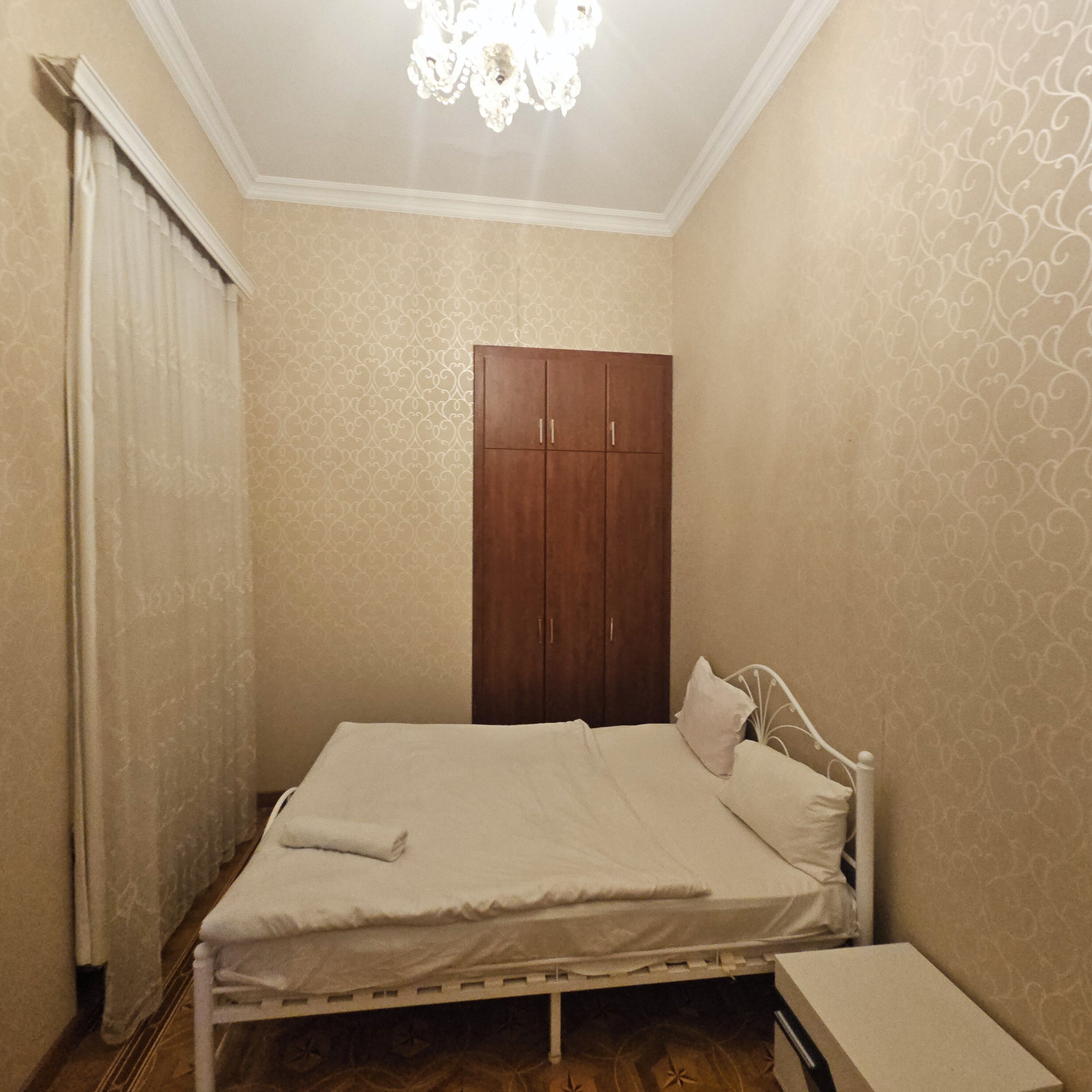 Un dormitorio con cama, armario y mesita de noche.