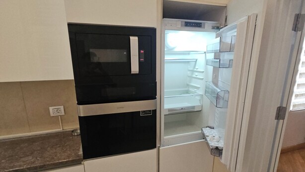 Una cocina compacta con microondas, refrigerador y una pequeña encimera.