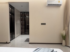 Ein Hotelzimmer mit einem Bett, einer Klimaanlage, einer Steckdose und einer Topfpflanze.