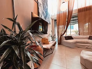 A living room with a sofa, a coffee table, a large plant, and a fireplace. - Luxury Provence Terrace (Medellín)