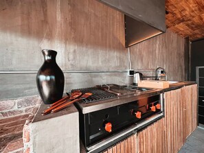 A kitchen with a built-in grill, a vase, and a kettle on the counter. - Luxury Penthouse in Provenza (Medellín)
