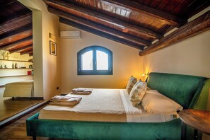 Ein Zimmer mit einem Bett, einem Fenster, einem Stuhl und einem Regal mit Gegenständen.