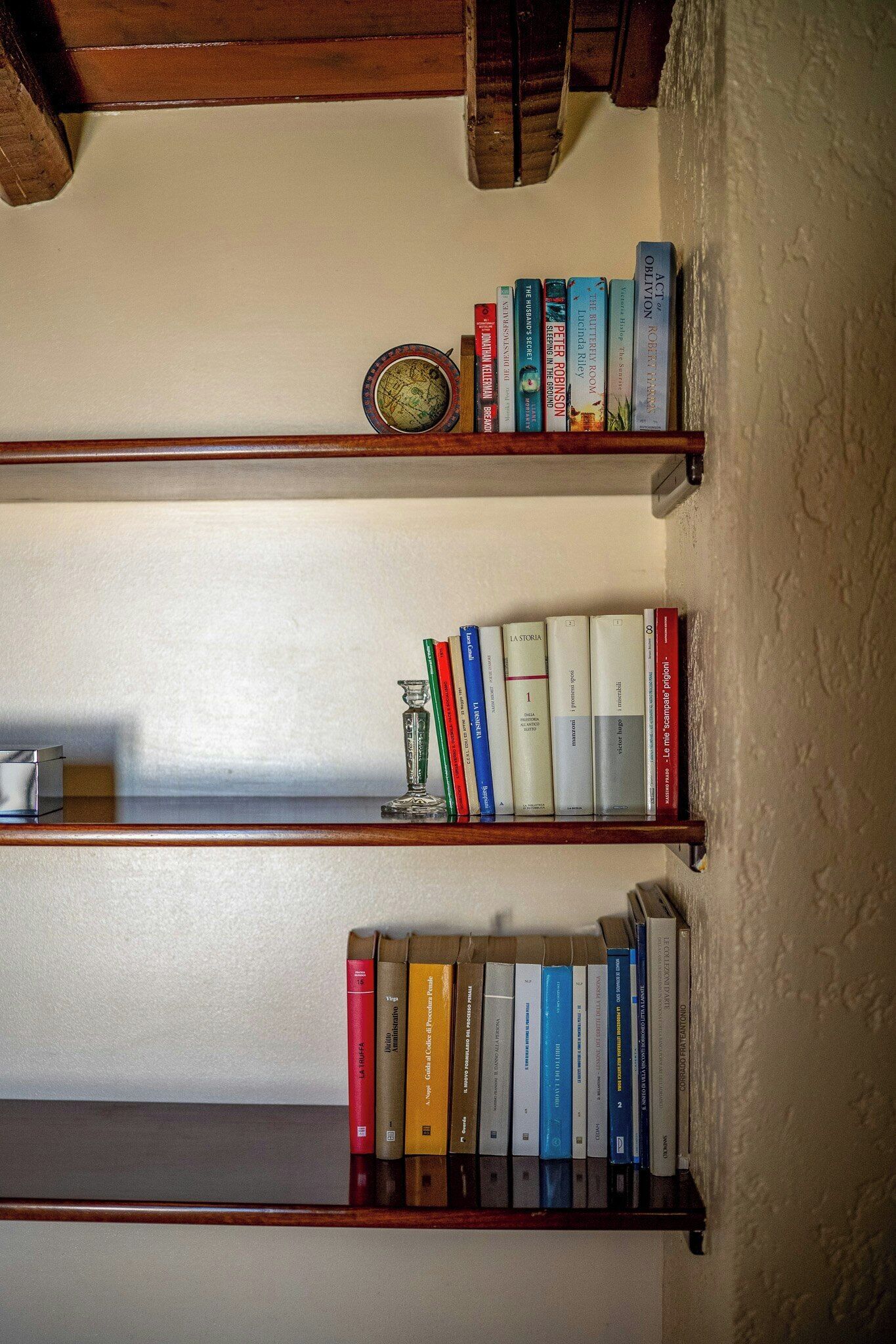 Dos estanterías de madera con libros y un plato decorativo.