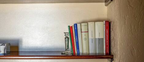 Dos estanterías de madera con libros y un plato decorativo.