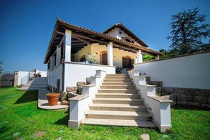 Uma casa de dois andares com uma escadaria que leva à entrada.