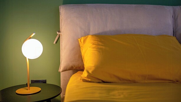 A bed with a pillow and a bedside lamp on a round table. - Sicilian villa with pool 400m above sea level (Avola)
