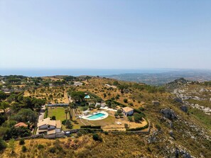 Ein Wohngebiet mit Pool, Häusern und hügeliger Landschaft.