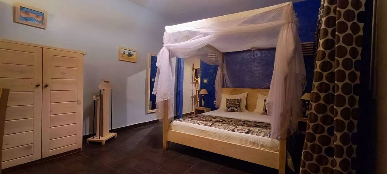 Un dormitorio con cama a dosel, armario y espejo.