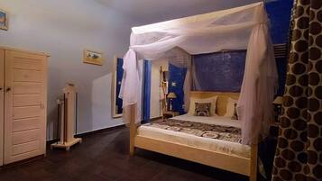 Un dormitorio con cama a dosel, armario y espejo.