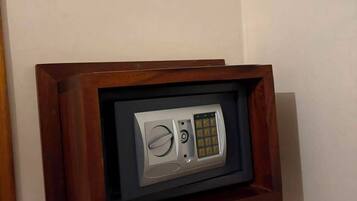 A framed object with a keypad and a circular dial, mounted on a wall.