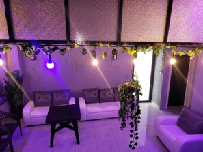 A room with a white sofa, a black coffee table, and hanging plants. - Luxury 6BR, 5-Bath, Sleeps 12+ – BBB Nation Oasis - Premium Kigali Group Stay (Kigali)