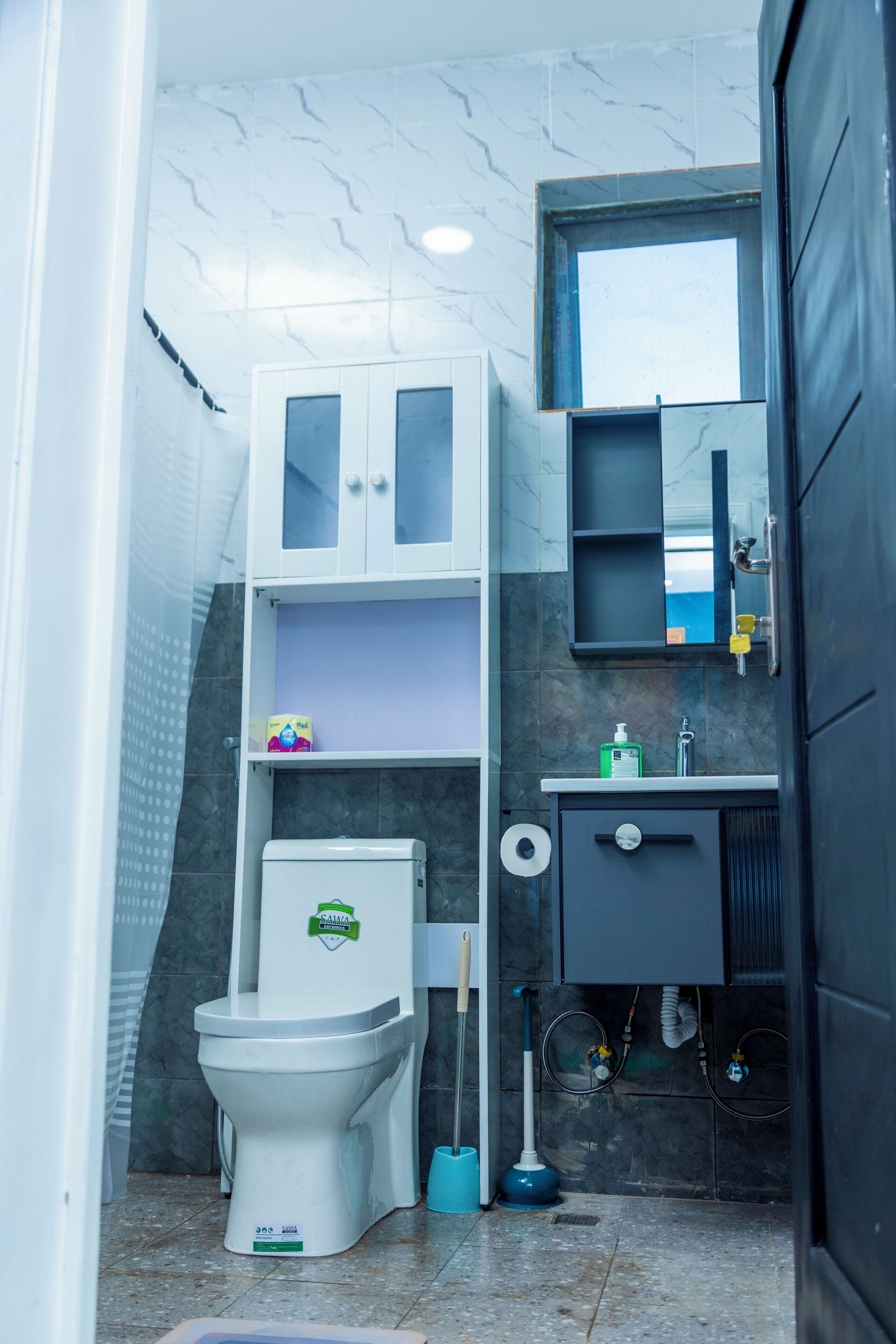Ein kleines Badezimmer mit Toilette, Waschbecken und Spiegel.