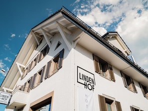 A hotel named 'Lindenhof' with a white facade, multiple windows, and a balcony.